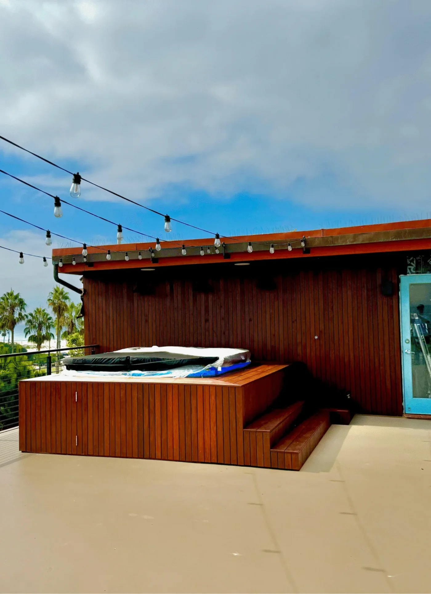 After: roof deck with a timber-clad hot tub surround and string lights