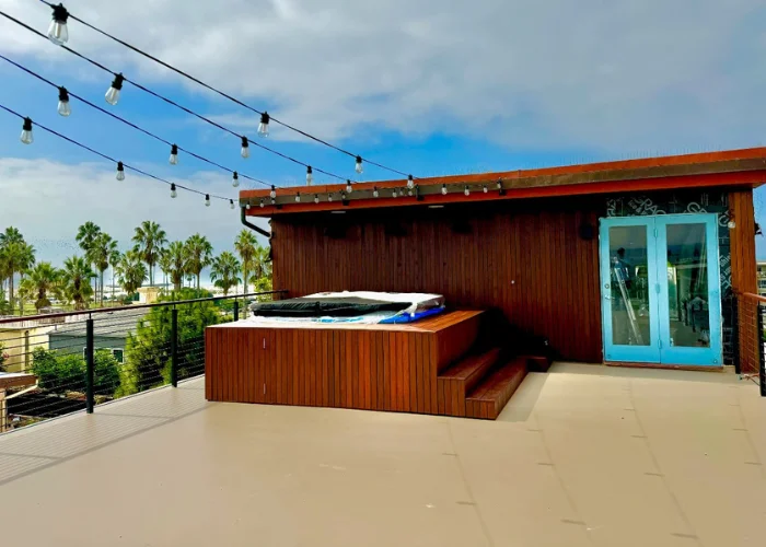 Deck with a built-in hot tub beside a timber-clad building