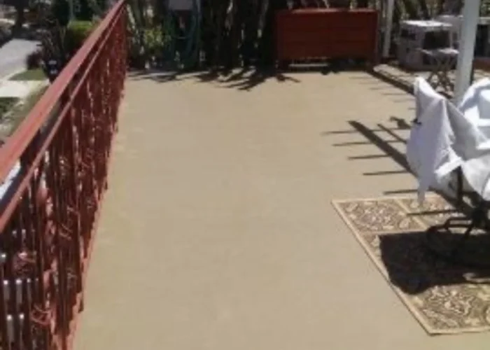 Freshly coated deck surface with a red metal railing