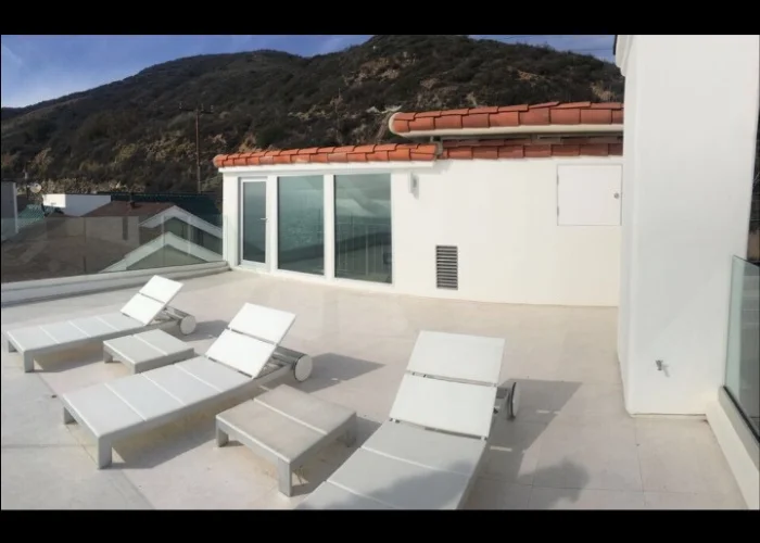 White house with a deck overlooking the hillside